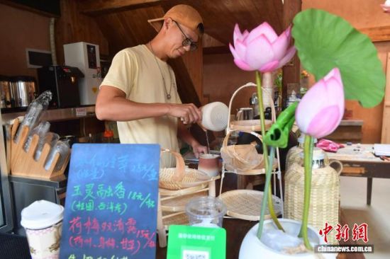 10月17日,在五夫镇兴贤古街的“龙鱼茶舍”,来自广东的“80后”青年莫健恩正在调制茶饮。 中新社记者 张斌 摄 10月17日,在五夫镇兴贤古街的“龙鱼茶舍”,来自广东的“80后”青年莫健恩正在调制茶饮。 中新社记者 张斌 摄