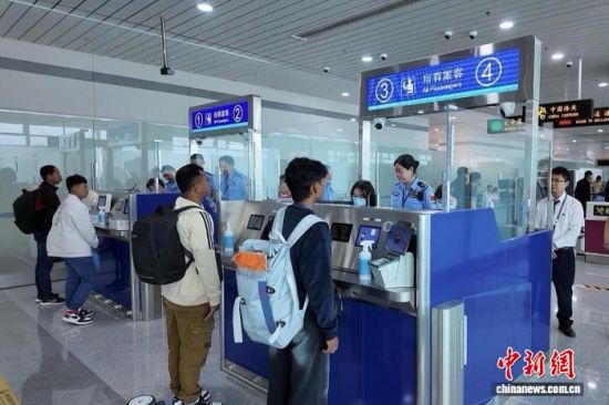 10月26日,福州机场边检站民警正在为K6592航班旅客办理过境手续。 王蔚然 摄 10月26日,福州机场边检站民警正在为K6592航班旅客办理过境手续。 王蔚然 摄