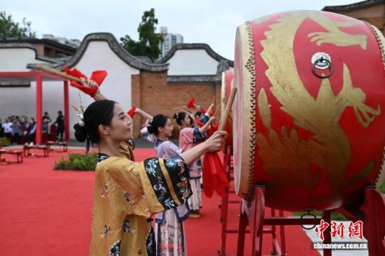 图为身穿福州三条簪装束的女子为新人们击鼓。中新社记者 吕明 摄 图为身穿福州三条簪装束的女子为新人们击鼓。中新社记者 吕明 摄