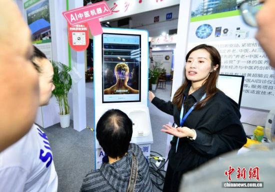 图为工作人员向参观者介绍AI中医机器人。中新社记者 张斌 摄 图为工作人员向参观者介绍AI中医机器人。中新社记者 张斌 摄