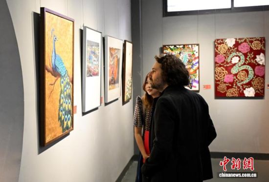 图为丙烯画作品《华羽辉煌》吸引参观者。中新社记者 吕明 摄 图为丙烯画作品《华羽辉煌》吸引参观者。中新社记者 吕明 摄