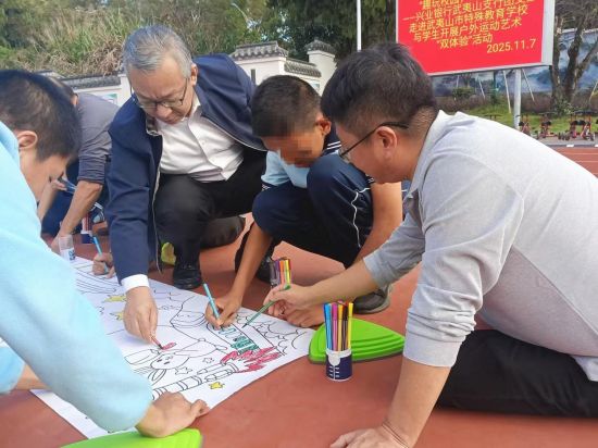 林伟斌(左二)与何发明(右一)手把手引导特殊儿童涂鸦 林伟斌(左二)与何发明(右一)手把手引导特殊儿童涂鸦