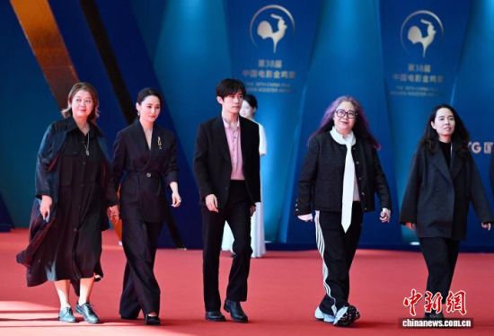 图为演员易烊千玺(中)等走进会场。中新社记者 王东明 摄 图为演员易烊千玺(中)等走进会场。中新社记者 王东明 摄