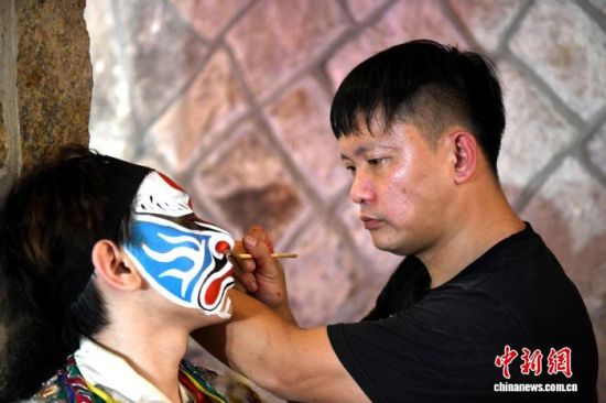 11月16日,“将来在福州 —— 第三届两岸青年家将脸谱绘画大赛” 在福州台江区举办,台湾青年面师庄俊益(右)正在绘制脸谱。 中新社记者 吕明 摄 11月16日,“将来在福州 —— 第三届两岸青年家将脸谱绘画大赛” 在福州台江区举办,台湾青年面师庄俊益(右)正在绘制脸谱。 中新社记者 吕明 摄