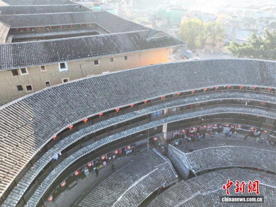 图为11月23日,游客在一土楼内参观。(无人机照片)中新社记者 张斌 摄 图为11月23日,游客在一土楼内参观。(无人机照片)中新社记者 张斌 摄