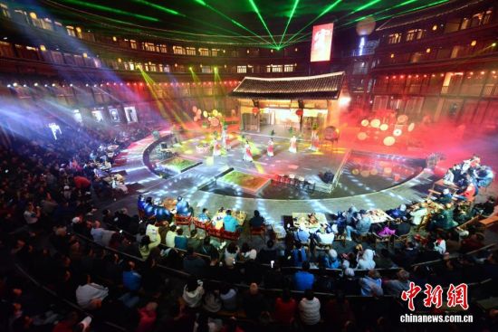 图为11月22日晚,游客在福建土楼王子景区观看歌舞剧《客》,沉浸式体验永定的风土人情。中新社记者 张斌 摄 图为11月22日晚,游客在福建土楼王子景区观看歌舞剧《客》,沉浸式体验永定的风土人情。中新社记者 张斌 摄