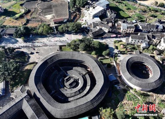 图为参赛选手从高北土楼群旁经过。(无人机照片)中新社记者 张斌 摄 图为参赛选手从高北土楼群旁经过。(无人机照片)中新社记者 张斌 摄