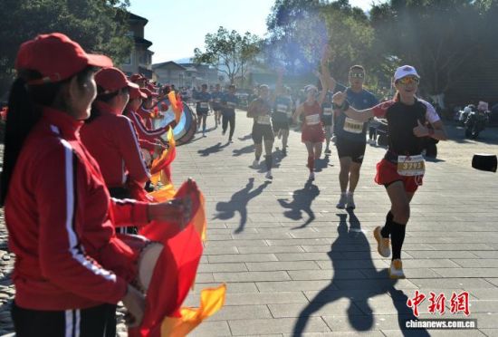 图为村民在赛道旁敲鼓为参赛选手加油助威。中新社记者 张斌 摄 图为村民在赛道旁敲鼓为参赛选手加油助威。中新社记者 张斌 摄