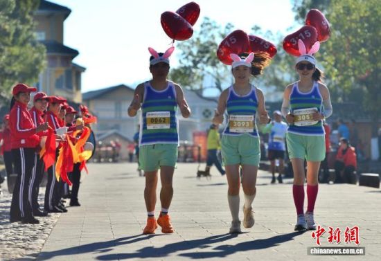 图为赛道上统一衣着、绑着写有时间气球的配速员吸引观赛者。中新社记者 张斌 摄 图为赛道上统一衣着、绑着写有时间气球的配速员吸引观赛者。中新社记者 张斌 摄