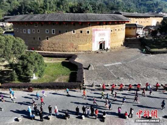 图为参赛选手从“福建土楼王”承启楼前经过。(无人机照片)中新社记者 张斌 摄 图为参赛选手从“福建土楼王”承启楼前经过。(无人机照片)中新社记者 张斌 摄