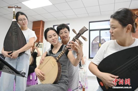 10月15日,在福建省漳州市芗城区锦歌传承中心,王素华指导锦歌学员弹奏月琴。中新社记者 张金川 摄 10月15日,在福建省漳州市芗城区锦歌传承中心,王素华指导锦歌学员弹奏月琴。中新社记者 张金川 摄
