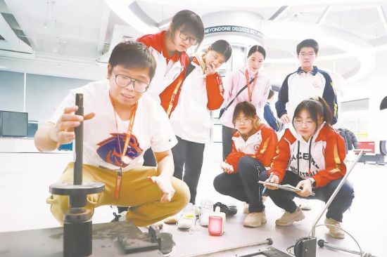 图为技术人员为同学们示范实验操作。 图为技术人员为同学们示范实验操作。