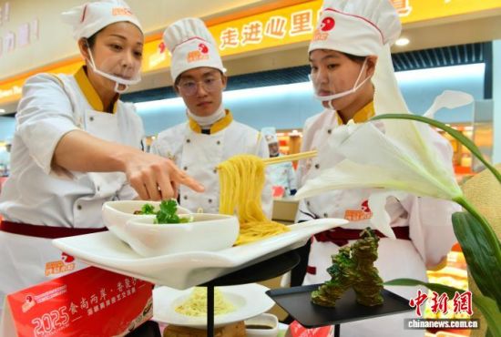 图为参赛队员在活动上交流美食制作。中新社记者 张斌 摄 图为参赛队员在活动上交流美食制作。中新社记者 张斌 摄
