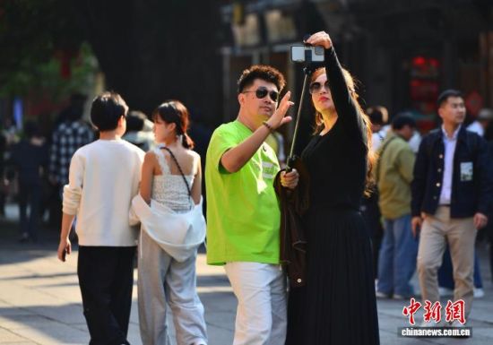 12月11日,福建福州最高温度达到25℃,一些游客穿着夏装在福州三坊七巷参观游玩。中新社记者 张斌 摄 12月11日,福建福州最高温度达到25℃,一些游客穿着夏装在福州三坊七巷参观游玩。中新社记者 张斌 摄