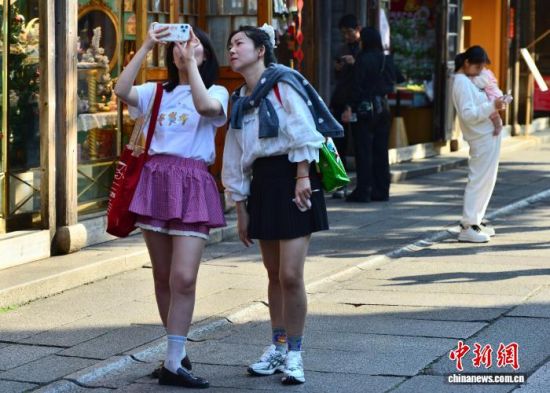 12月11日,福建福州最高温度达到25℃,一些游客穿着夏装在福州三坊七巷参观游玩。中新社记者 张斌 摄 12月11日,福建福州最高温度达到25℃,一些游客穿着夏装在福州三坊七巷参观游玩。中新社记者 张斌 摄