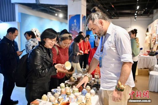 12月12日,荷兰民间艺人向市民、游客介绍陶瓷展品。中新社记者 王东明 摄 12月12日,荷兰民间艺人向市民、游客介绍陶瓷展品。中新社记者 王东明 摄