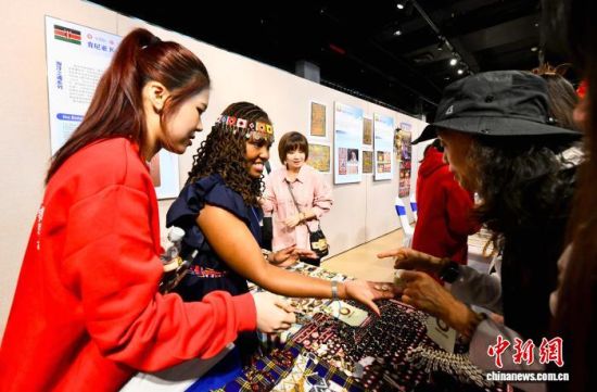 12月12日,肯尼亚民间艺人(左二)向市民、游客介绍“海洋之魂系列”展品。中新社记者 王东明 摄 12月12日,肯尼亚民间艺人(左二)向市民、游客介绍“海洋之魂系列”展品。中新社记者 王东明 摄