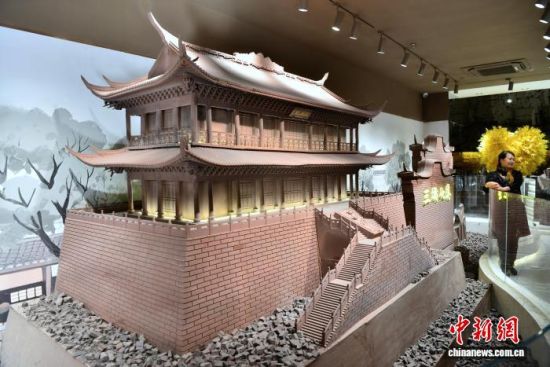 12月11日,游客在用巧克力雕塑的建筑模型旁拍照留念。中新社记者 张斌 摄 12月11日,游客在用巧克力雕塑的建筑模型旁拍照留念。中新社记者 张斌 摄