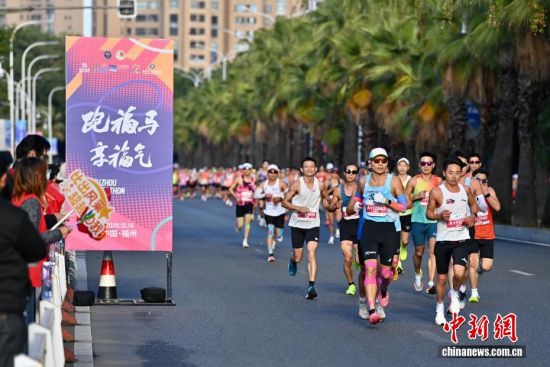 图为选手奔跑在美丽的江滨赛道上。中新社记者 王东明 摄 图为选手奔跑在美丽的江滨赛道上。中新社记者 王东明 摄
