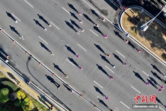 图为选手奔跑在美丽的江滨赛道上。(无人机照片)中新社记者 王东明 摄 图为选手奔跑在美丽的江滨赛道上。(无人机照片)中新社记者 王东明 摄