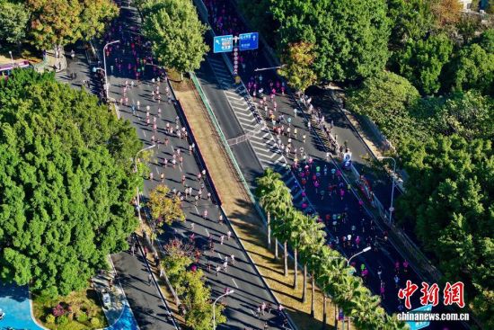 图为选手奔跑在美丽的江滨赛道上。(无人机照片)中新社记者 王东明 摄 图为选手奔跑在美丽的江滨赛道上。(无人机照片)中新社记者 王东明 摄