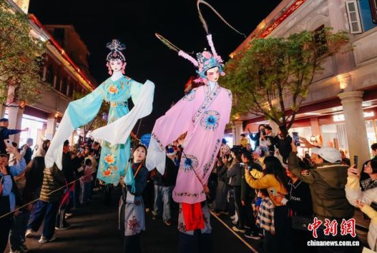 图为木偶巡游吸引大批民众围观。中新社记者 王东明 摄 图为木偶巡游吸引大批民众围观。中新社记者 王东明 摄