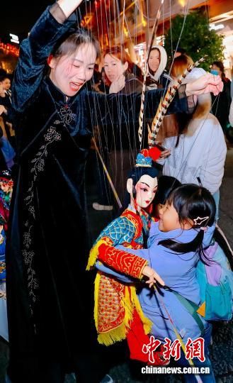 图为小朋友与木偶热情拥抱。中新社记者 王东明 摄 图为小朋友与木偶热情拥抱。中新社记者 王东明 摄