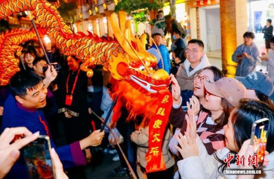 图为龙型木偶与观众互动。中新社记者 王东明 摄 图为龙型木偶与观众互动。中新社记者 王东明 摄