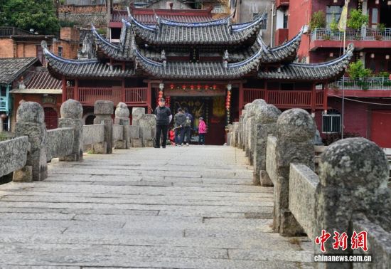 图为12月28日,位于古镇内的圣王庙。圣王庙坐北朝南,背靠棋盘山,面朝迥龙桥,由跨街亭、圣王殿、观音阁三部分组成,古色古香、雕梁画栋。它与南平顺昌圣王庙、厦门同安圣王庙共同位列福建奉祀齐天大圣的三大庙宇,也是台湾许多圣王庙的祖庙。中新社记者 张斌 摄 图为12月28日,位于古镇内的圣王庙。圣王庙坐北朝南,背靠棋盘山,面朝迥龙桥,由跨街亭、圣王殿、观音阁三部分组成,古色古香、雕梁画栋。它与南平顺昌圣王庙、厦门同安圣王庙共同位列福建奉祀齐天大圣的三大庙宇,也是台湾许多圣王庙的祖庙。中新社记者 张斌 摄