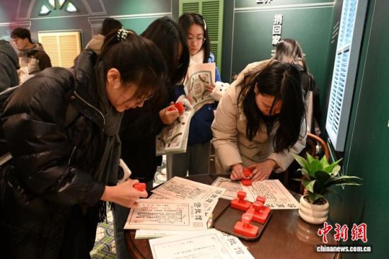观众正在体验在侨批上盖如意印章。中新网记者 吕明 摄 观众正在体验在侨批上盖如意印章。中新网记者 吕明 摄