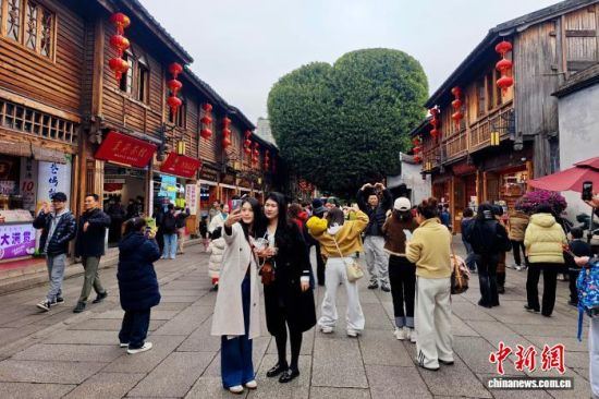 1月24日,福建福州,游客在南后街爱心树前留影。中新社记者 王东明 摄 1月24日,福建福州,游客在南后街爱心树前留影。中新社记者 王东明 摄
