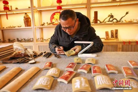 图为曹永生正在雕刻新春福字作品。黄尉峰摄 图为曹永生正在雕刻新春福字作品。黄尉峰摄