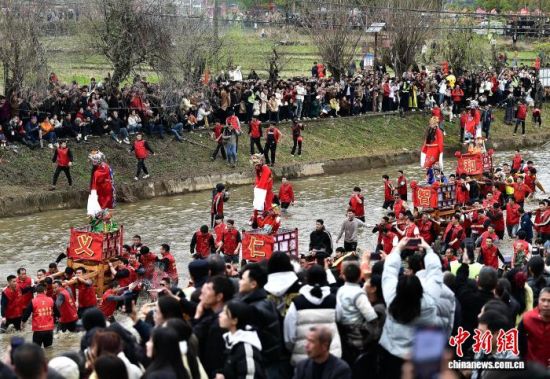 图为村民们抬着“古事”在水中逆行。中新社记者 张斌 摄 图为村民们抬着“古事”在水中逆行。中新社记者 张斌 摄