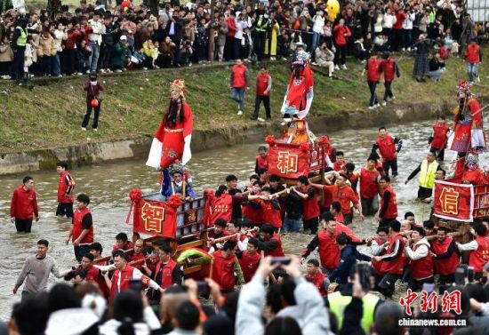 图为村民们抬着“古事”在水中逆行。中新社记者 张斌 摄 图为村民们抬着“古事”在水中逆行。中新社记者 张斌 摄