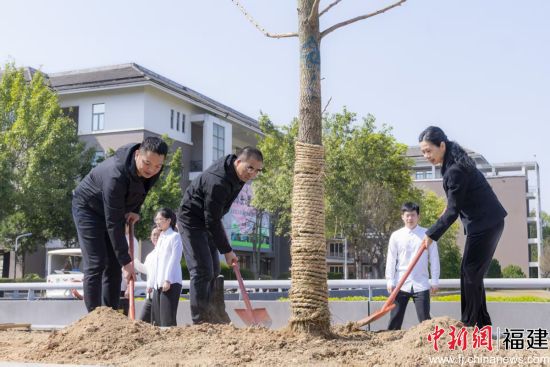 图为与会领导、校友与学生代表共同为银杏林培土浇水。谭钦文 摄 图为与会领导、校友与学生代表共同为银杏林培土浇水。谭钦文 摄