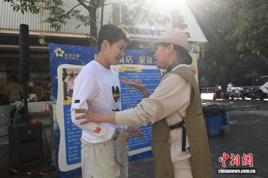 4月1日,“看见星光·守护心愿”4·2世界孤独症关注日主题倡导活动开始前,“星点心愿”茶咖饺子店里的辅导老师谢雅芳正在与孤独症青年方俊涵(左)沟通。中新网记者 吕明 摄 4月1日,“看见星光·守护心愿”4·2世界孤独症关注日主题倡导活动开始前,“星点心愿”茶咖饺子店里的辅导老师谢雅芳正在与孤独症青年方俊涵(左)沟通。中新网记者 吕明 摄