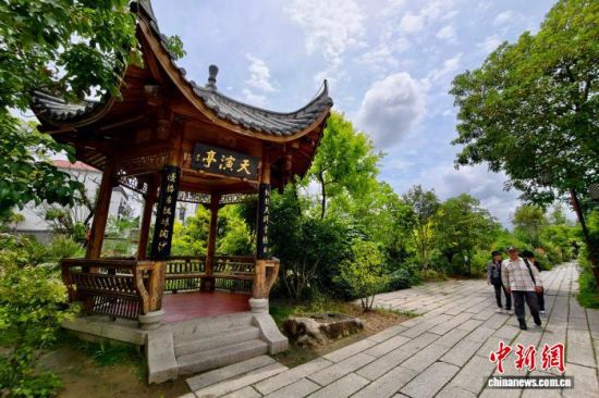 5月16日,游客经过阳岐村天演亭。中新社记者 王东明 摄 5月16日,游客经过阳岐村天演亭。中新社记者 王东明 摄
