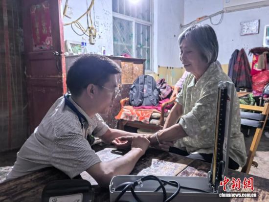 图为李创业在老家为邻里看诊。 记者 阚力 摄 图为李创业在老家为邻里看诊。 记者 阚力 摄