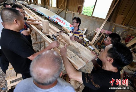 图为6月8日,在方庄村“龙舟世家”方忠雄龙舟厂内,龙舟匠人与顾客交流制作技艺。中新社记者 王东明 摄 图为6月8日,在方庄村“龙舟世家”方忠雄龙舟厂内,龙舟匠人与顾客交流制作技艺。中新社记者 王东明 摄