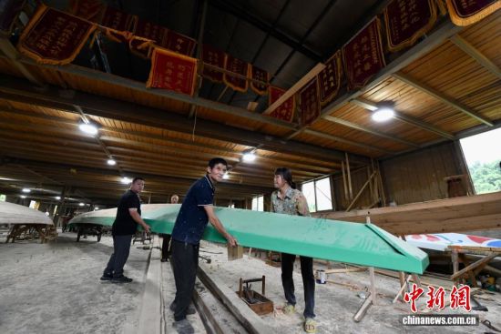 图为6月8日,在方庄村“龙舟世家”方忠雄龙舟厂内,工人正在转运龙舟。中新社记者 王东明 摄 图为6月8日,在方庄村“龙舟世家”方忠雄龙舟厂内,工人正在转运龙舟。中新社记者 王东明 摄