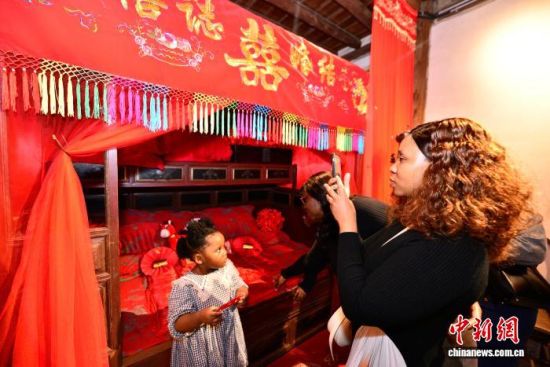 图为外籍教师和家属在中国历史文化名村——福州仓山林浦村一民宅内了解当地婚俗。中新社记者 张斌 摄 图为外籍教师和家属在中国历史文化名村——福州仓山林浦村一民宅内了解当地婚俗。中新社记者 张斌 摄