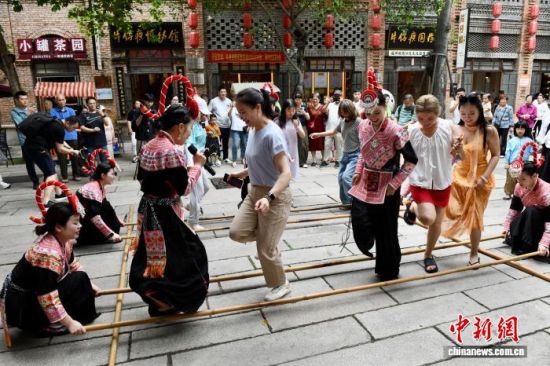 6月13日,市民体验畲族竹竿舞。中新社记者 王东明 摄 6月13日,市民体验畲族竹竿舞。中新社记者 王东明 摄