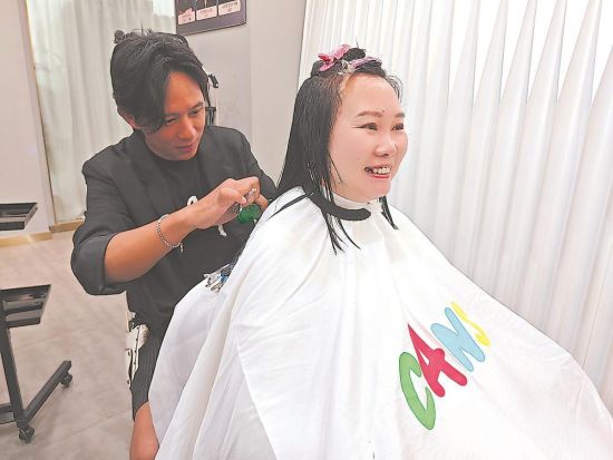 台青韩再村在为顾客剪发。 福建日报记者 吴洪 摄 台青韩再村在为顾客剪发。 福建日报记者 吴洪 摄