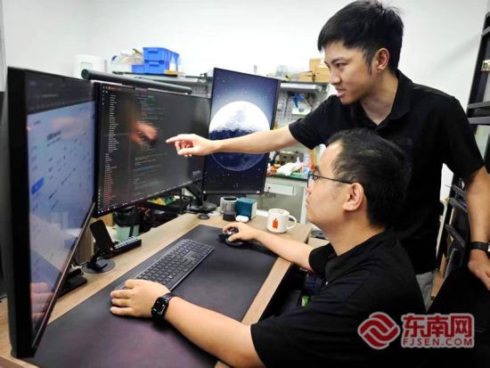 孙智聪(右)与研发人员探讨AI智能体。 孙智聪(右)与研发人员探讨AI智能体。