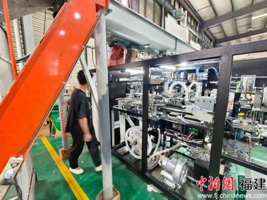 图: 中利机械工作人员正在调试食用菌套袋装袋机 图: 中利机械工作人员正在调试食用菌套袋装袋机