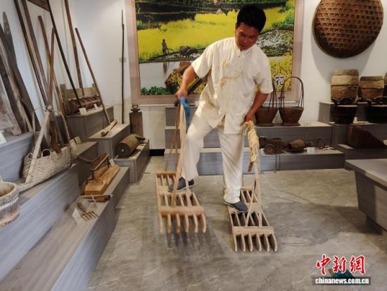 联合梯田农耕文化博物馆馆长廖燕楚在馆内向游客展示梯田传统农具的使用方法。雷朝良摄 联合梯田农耕文化博物馆馆长廖燕楚在馆内向游客展示梯田传统农具的使用方法。雷朝良摄