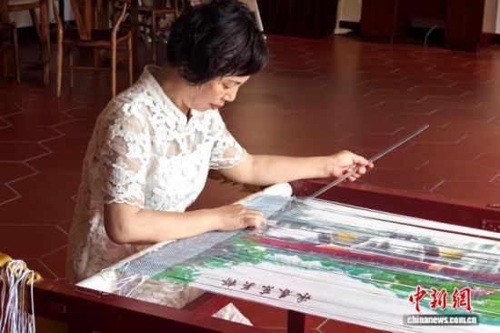 5月21日,方碧双在位于福建永春县桃城镇花石村的永芳纸织画社展示馆创作。中新社记者 孙虹 摄 5月21日,方碧双在位于福建永春县桃城镇花石村的永芳纸织画社展示馆创作。中新社记者 孙虹 摄