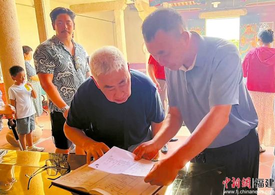 图为陈永基翻看族谱。翔安区委宣传部 供图 图为陈永基翻看族谱。翔安区委宣传部 供图
