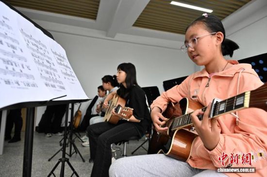 7月18日,宁夏固原市隆德县青少年活动中心,孩子们在兴趣班上学习吉他。中新社记者 张斌 摄 7月18日,宁夏固原市隆德县青少年活动中心,孩子们在兴趣班上学习吉他。中新社记者 张斌 摄