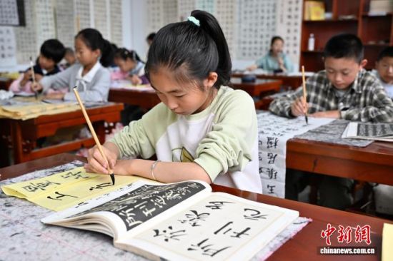 7月18日,宁夏固原市隆德县青少年活动中心,孩子们在兴趣班上学习书法。中新社记者 张斌 摄 7月18日,宁夏固原市隆德县青少年活动中心,孩子们在兴趣班上学习书法。中新社记者 张斌 摄